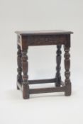 A 17th century and later oak joint stool having carved frieze decoration, on turned and carved legs,