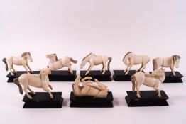 A set of eight early 20th century Chinese ivory Mu Wang horses on wooden stands,