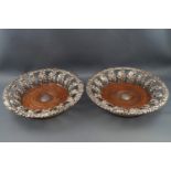 A pair of George III silver coasters with cast flower head and scrolling foliate rims supported by