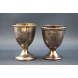 Two silver egg cups, both with cast rims and engraved with initials,