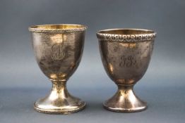 Two silver egg cups, both with cast rims and engraved with initials,