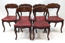 A set of six Victorian mahogany dining chairs on cabriole legs and with red leatherette seats