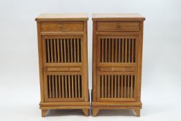 A pair of modern teak cupboards, each with a single shelf and drawer,