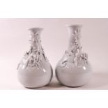 A pair of Chinese porcelain vases with applied models of dragons to the necks,