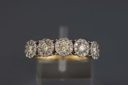 A yellow and white metal half hoop ring set with five round diamond clusters.