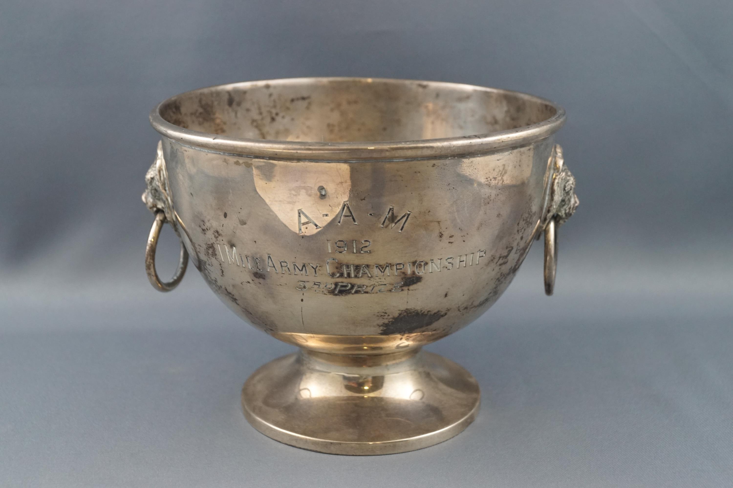 A round silver bowl, with two lion mask and ring handles, on flared foot,