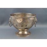 A round silver bowl, with two lion mask and ring handles, on flared foot,