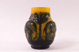 A modern Galle style moulded yellow glass vase, decorated with an elephant and palm trees design,