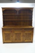 A modern oak dresser with carved oakleaf detail,