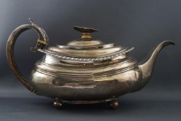 A George IV silver tea pot, of boat form with flowerhead finial, on four ball feet,