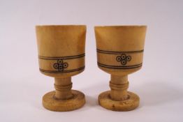 A pair of Sudanese turned bone egg cups and a krull bone container,