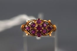 A yellow metal ring set with nine round rubies. Hallmarked 9ct gold, London, 1979. Size: M1/2 2.