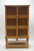 A modern teak standing bookcase with three shelves, two drawers and an undershelf,