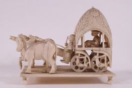 An early 20th century ivory carving of a carriage being pulled by oxon,