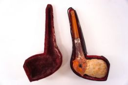 An amber pipe with clay bowl in the form of a bird with glass eyes, 15cm in length in fitted case.