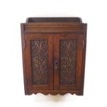 An Edwardian carved oak smoker's cabinet, 45cm high x 32cm wide x 16.