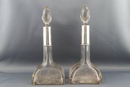 A pair of Edwardian silver mounted glass scent bottles, ribbon and flower engraved decoration,