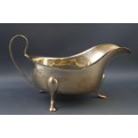 A silver sauce boat, with loop handle and three flared feet, by Barker Ellis Silver Co.