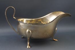 A silver sauce boat, with loop handle and three flared feet, by Barker Ellis Silver Co.