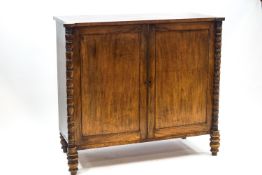 A George IV mahogany linen press with two panelled doors enclosing three sliding shelves,