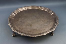 A silver salver with beaded rim, on three ball and claw feet, 20cm diameter, London 1923,
