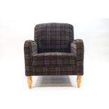 A modern tartan upholstered armchair with metal studding to the sides