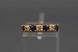 A yellow metal half hoop ring set with sapphires and diamonds.