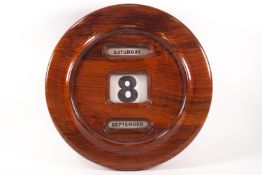 A large mahogany cased wall mounted calendar, with rolling date and days,