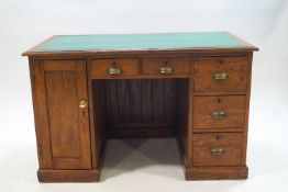 An early 20th century pitch pine kneehole desk with five drawers and cupboard,