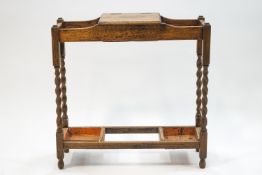 An early 20th century oak stickstand with central lidded compartment,