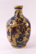 An Isnik style pottery vase, painted with a fish, a bird and flowers on a yellow ground,