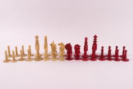 An early 20th century turned ivory and red stained chess set, King 7.