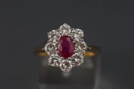A yellow and white metal cluster ring set with a central ruby and eight round brilliant cut