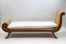 A modern hardwood day bed with scrolling cane ends,