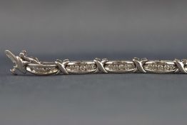 A white metal diamond line bracelet with X and bar design. Estimated weight of (60) diamonds 1.