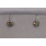 A white metal pair of single stone diamond stud earrings. Approx 0.