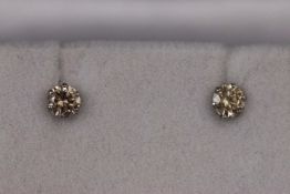 A white metal pair of single stone diamond stud earrings. Approx 0.