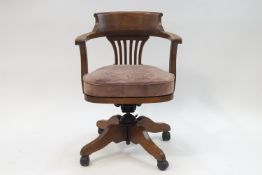 An early 20th century oak office swivel chair with leather seat,