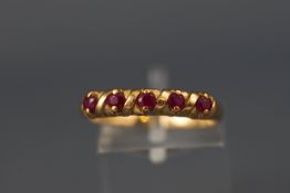 A yellow metal half hoop ruby ring. Hallmarked 9ct gold, Birmingham, 1995. Size: O 2.