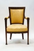 An Empire style mahogany armchair on slender tapering legs with gilt metal mounts and paw feet,