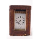 A small French brass carriage clock, the enamel dial with Roman numerals and five minute markers,