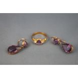 A yellow metal pair of two stone drop earrings each set with amethyst together with a gold plated