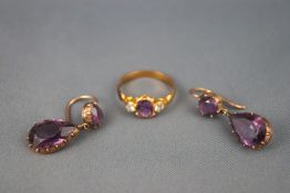 A yellow metal pair of two stone drop earrings each set with amethyst together with a gold plated