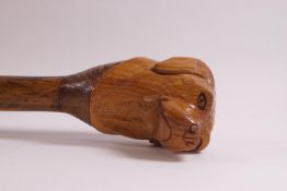 A walking stick carved with the head of a dog,