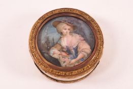 An 18th century circular ivory box, the cover inset with a painted portrait of a lady in a bonnet,