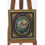 An oval print of a flower fairy on ceramic panel, within an ornate gold and black painted frame,