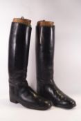 A pair of gentleman's black leather riding boots and wooden trees