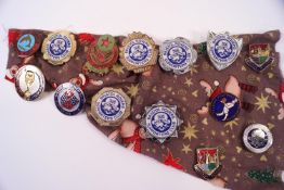 Twelve football badges and a fishing badge