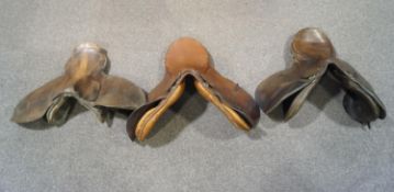 Three leather horse saddles