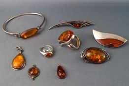 A collection of white metal and amber jewellery, comprising three pendants, three brooches,